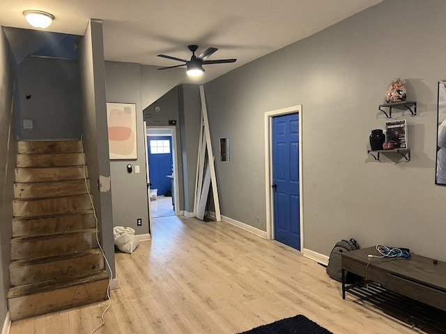 interior space featuring baseboards, light wood-style flooring, stairway, and ceiling fan