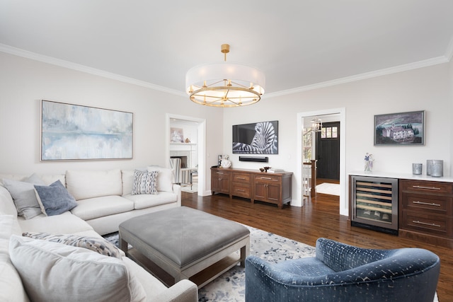 living area with an inviting chandelier, ornamental molding, baseboards, wine cooler, and dark wood-style floors