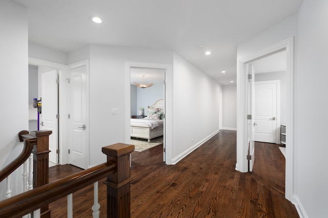 corridor with recessed lighting, baseboards, an upstairs landing, and dark wood-style floors
