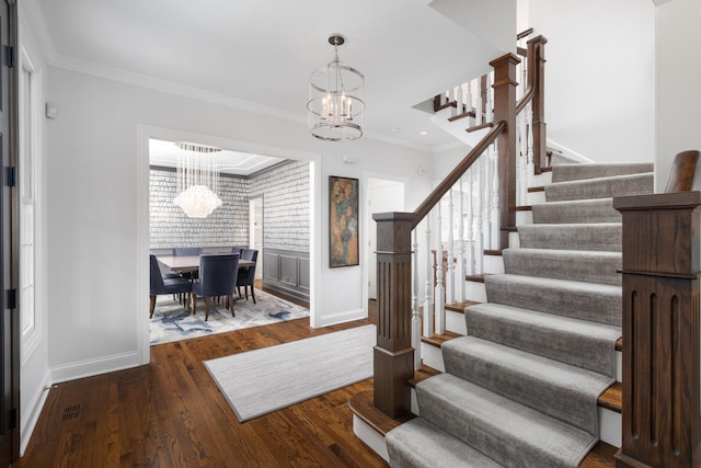 staircase with baseboards, ornamental molding, wood finished floors, and a notable chandelier