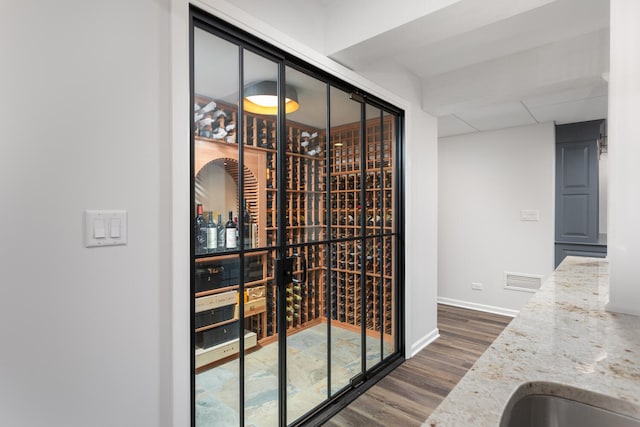wine room featuring a sink, baseboards, dark wood-style flooring, and visible vents