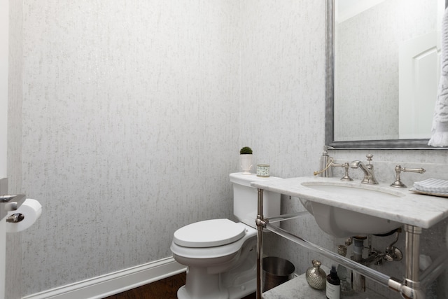 half bath featuring wood finished floors and toilet