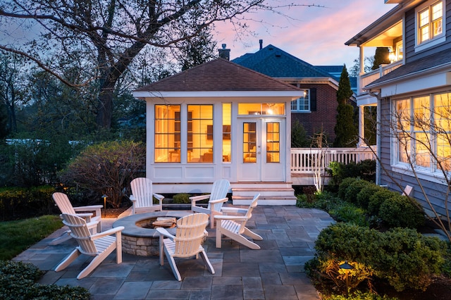 back of house featuring a fire pit, an outdoor structure, roof with shingles, and a patio area