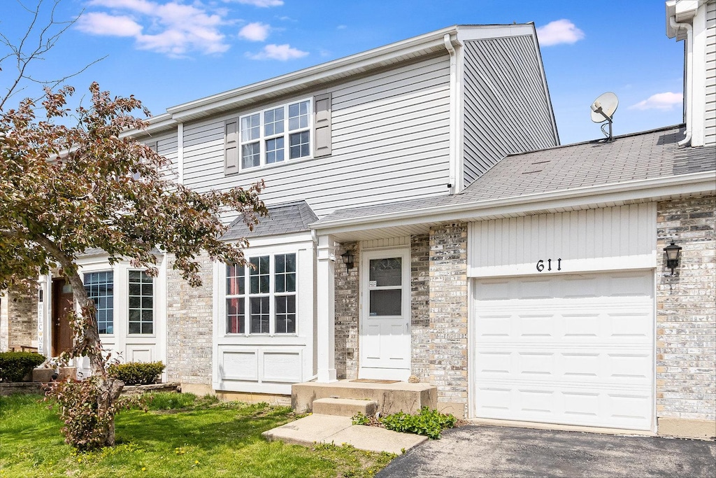 611 Cedar Ct, Romeoville, IL 60446 - view of front of house with a garage, a front lawn, aphalt driveway, and stone siding