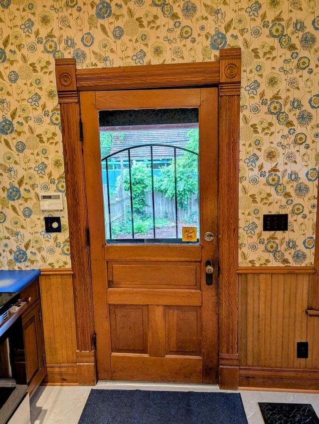 907 W Church St, Champaign, IL 61821 - doorway to outside with wallpapered walls, wainscoting, and wooden walls