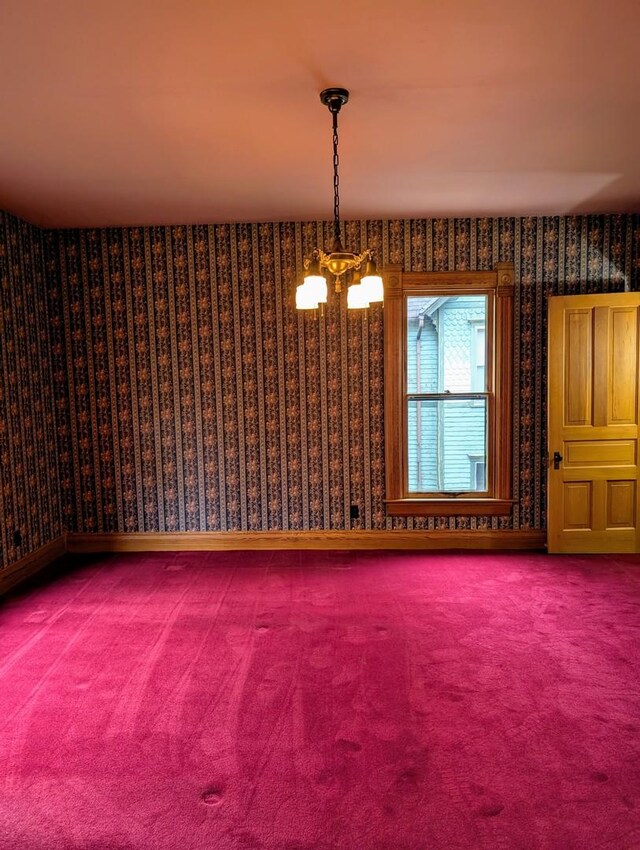 907 W Church St, Champaign, IL 61821 - empty room featuring wallpapered walls, carpet flooring, and a chandelier