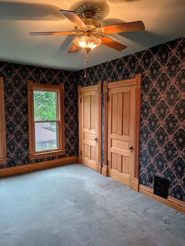 907 W Church St, Champaign, IL 61821 - unfurnished bedroom featuring carpet, a ceiling fan, baseboards, and wallpapered walls