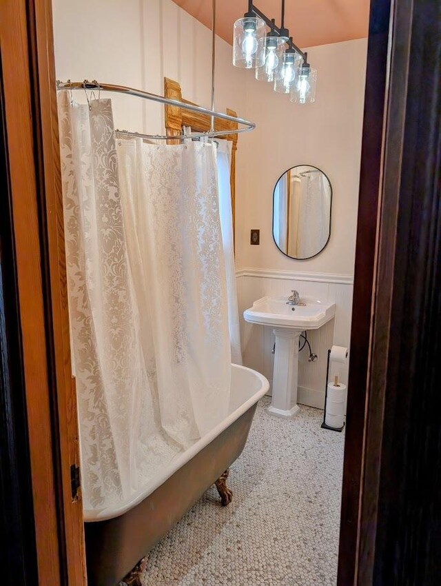 907 W Church St, Champaign, IL 61821 - bathroom featuring a freestanding bath, wainscoting, and a shower with curtain