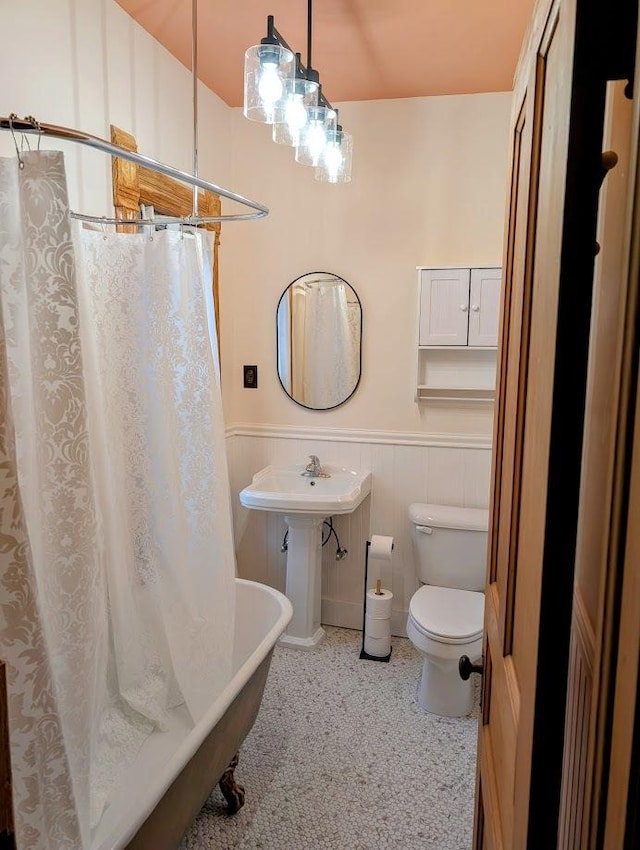 907 W Church St, Champaign, IL 61821 - bathroom with toilet, a wainscoted wall, a bath, and a shower with shower curtain