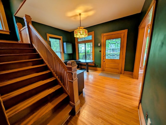907 W Church St, Champaign, IL 61821 - entrance foyer featuring stairs, light wood-style floors, a chandelier, and baseboards