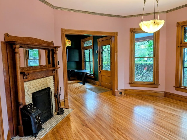 907 W Church St, Champaign, IL 61821 - unfurnished living room featuring light wood-style floors, ornamental molding, baseboards, and a brick fireplace
