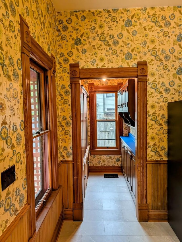 907 W Church St, Champaign, IL 61821 - hallway with wallpapered walls, wainscoting, and healthy amount of natural light