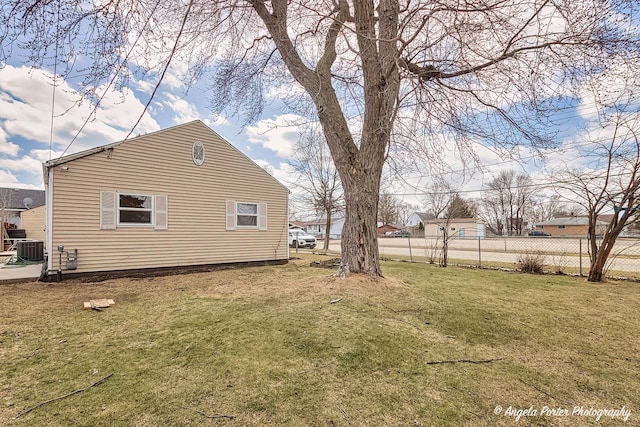 view of yard featuring central AC unit and fence