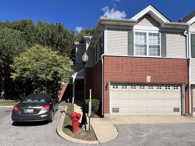 view of front of property featuring brick siding and a garage