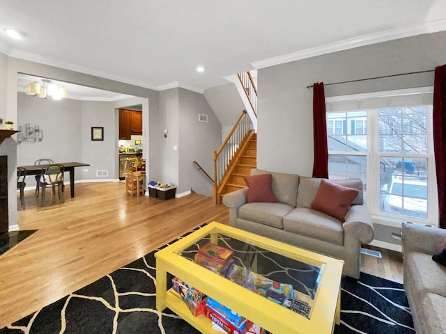 living room featuring visible vents, recessed lighting, wood finished floors, stairs, and ornamental molding
