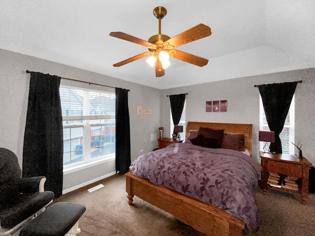 carpeted bedroom with baseboards, visible vents, and ceiling fan