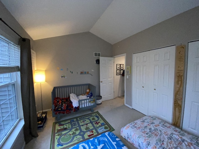 carpeted bedroom featuring lofted ceiling, visible vents, and multiple windows