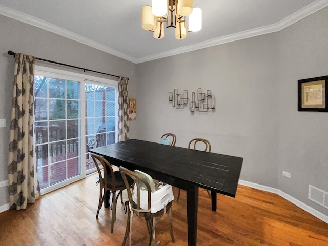 dining area featuring light wood finished floors, baseboards, a notable chandelier, and crown molding