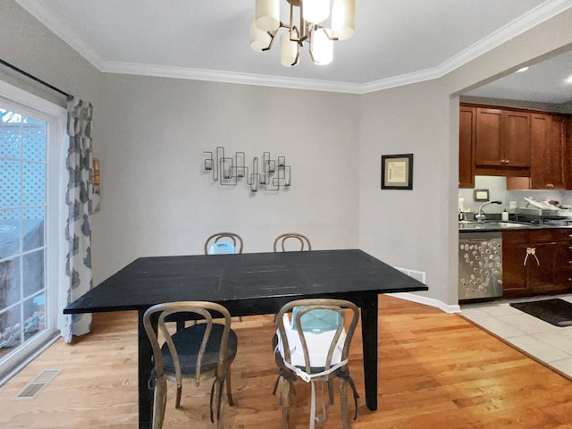 dining space featuring ornamental molding, a chandelier, visible vents, and light wood-style flooring