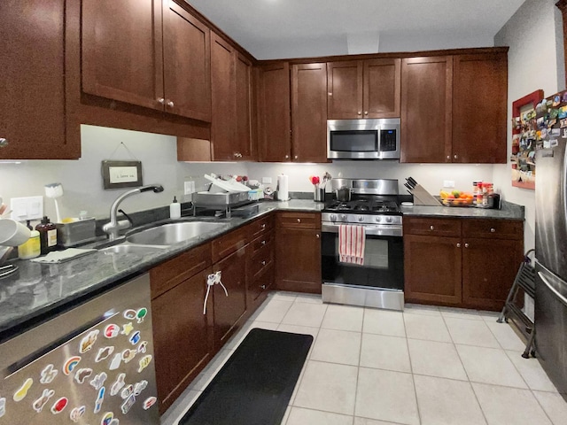 kitchen featuring stainless steel appliances, a sink, and light tile patterned floors