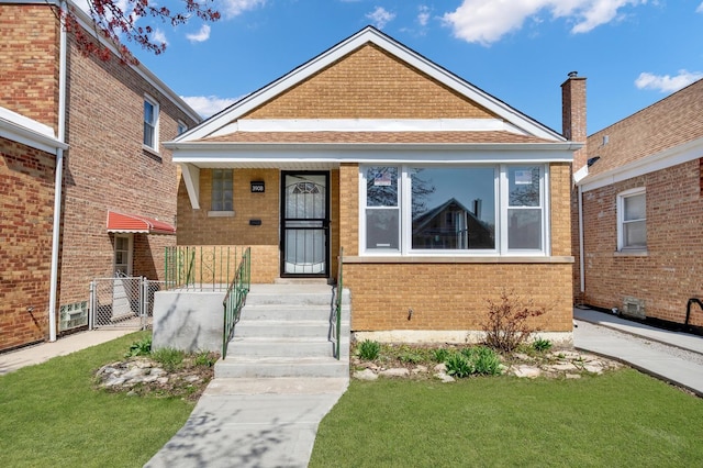 view of front of home with a front lawn and brick siding
