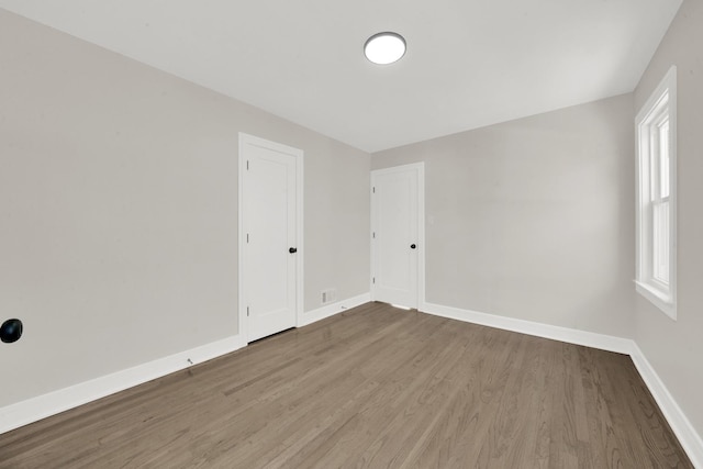 empty room with wood finished floors and baseboards