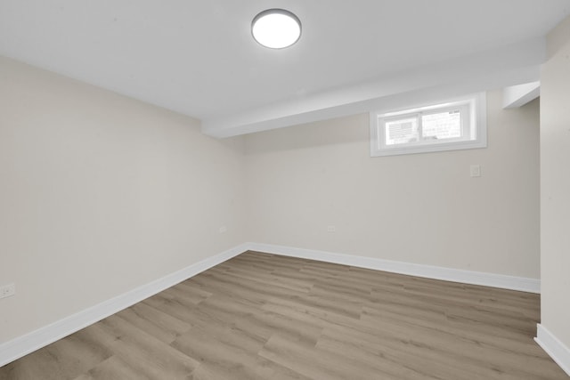 below grade area featuring baseboards and light wood-type flooring