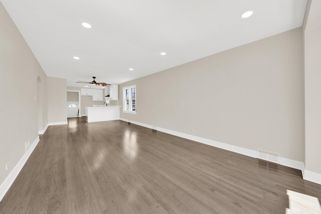 unfurnished living room featuring recessed lighting, visible vents, a ceiling fan, baseboards, and dark wood-style flooring