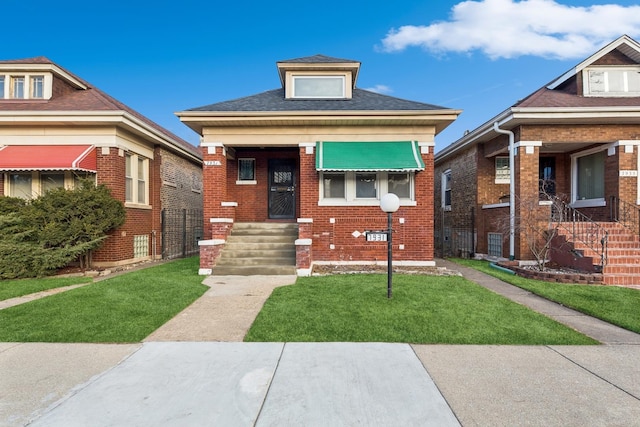 bungalow featuring a front lawn and brick siding
