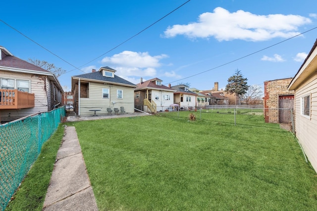 rear view of house featuring a fenced backyard, a yard, and a residential view