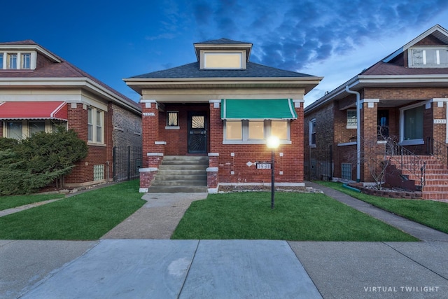 bungalow featuring a front lawn and brick siding