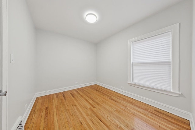 spare room with baseboards, wood finished floors, and visible vents