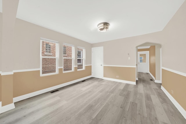 3435 W 71st Pl, Chicago, IL 60629 - spare room featuring baseboards, visible vents, arched walkways, and light wood-style flooring