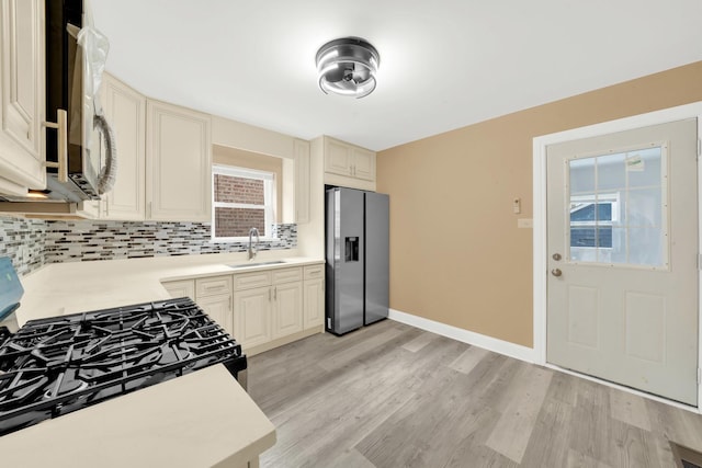 3435 W 71st Pl, Chicago, IL 60629 - kitchen featuring cream cabinets, a sink, appliances with stainless steel finishes, and tasteful backsplash
