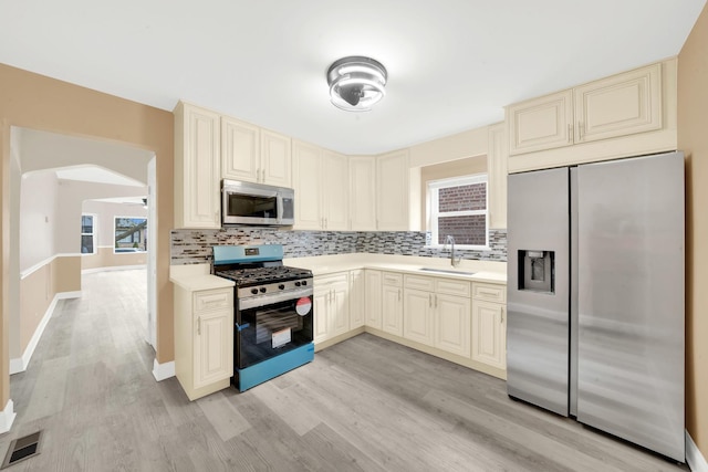 3435 W 71st Pl, Chicago, IL 60629 - kitchen featuring a sink, appliances with stainless steel finishes, light wood-style floors, visible vents, and cream cabinets