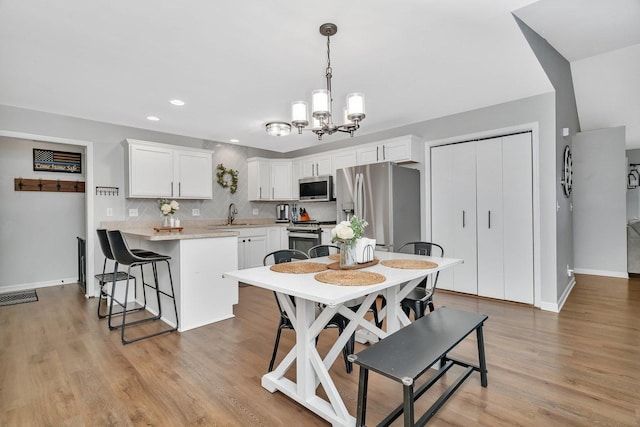 141 Scott Ave, Oglesby, IL 61348 - dining area with light wood-type flooring, visible vents, baseboards, and an inviting chandelier