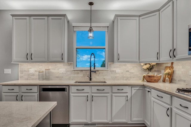 kitchen with stainless steel dishwasher, light stone counters, a sink, decorative light fixtures, and backsplash