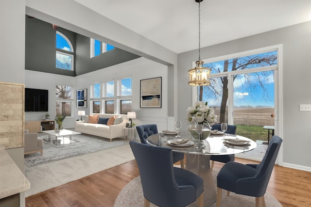dining area with wood finished floors, an inviting chandelier, and a healthy amount of sunlight
