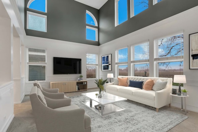 living room featuring a decorative wall, carpet floors, and a high ceiling
