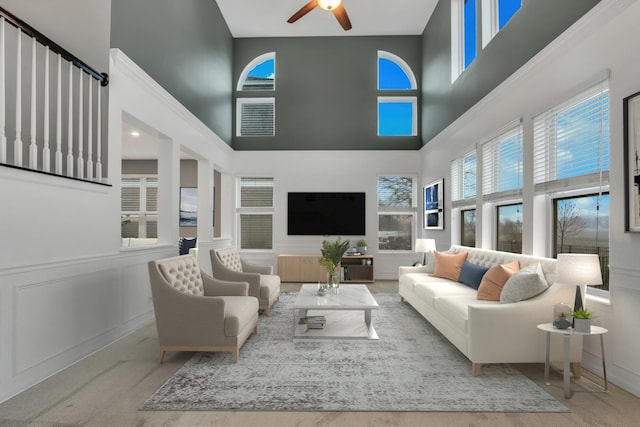 living area featuring a towering ceiling and a ceiling fan