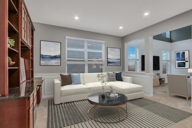 living room with recessed lighting, a decorative wall, a wainscoted wall, and light carpet