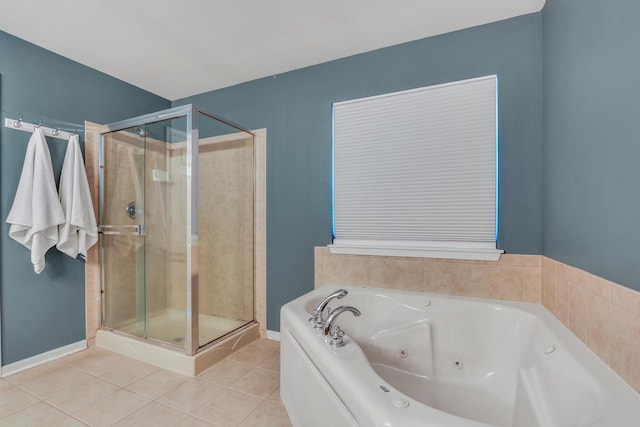 bathroom with baseboards, tile patterned flooring, a shower stall, and a tub with jets