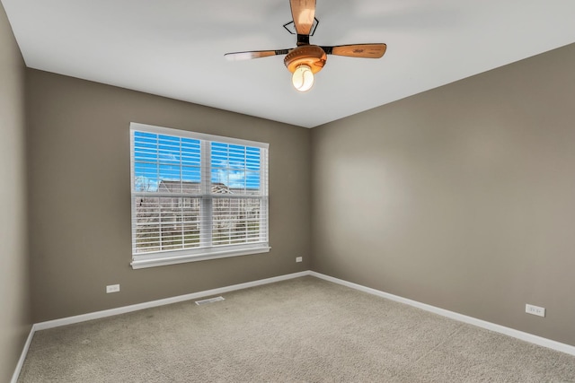 empty room featuring ceiling fan, baseboards, visible vents, and carpet