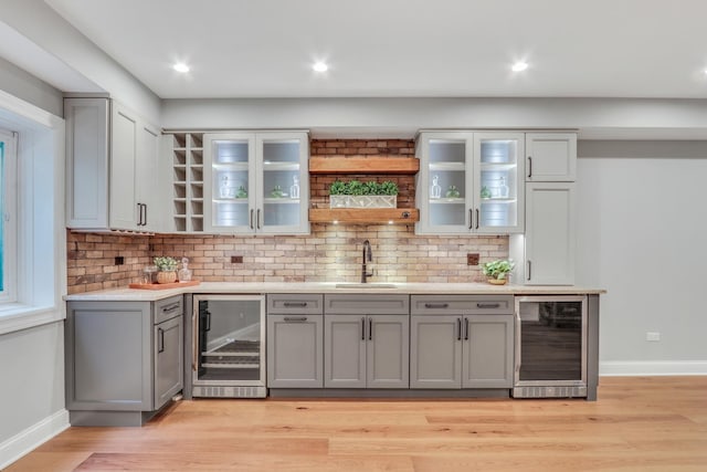 bar featuring baseboards, a sink, and beverage cooler