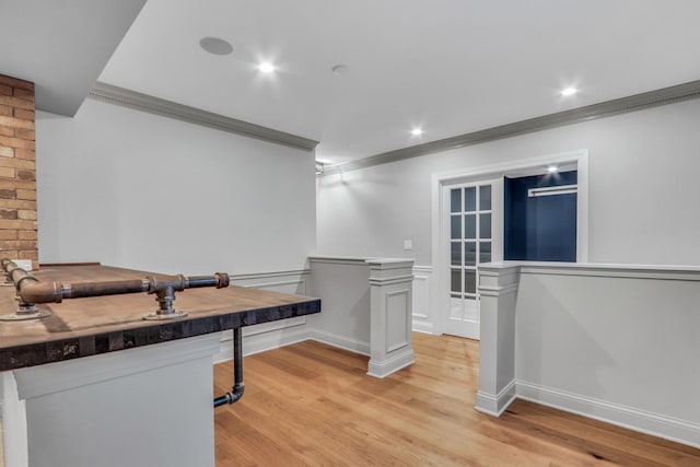 kitchen featuring light wood finished floors, baseboards, and ornamental molding