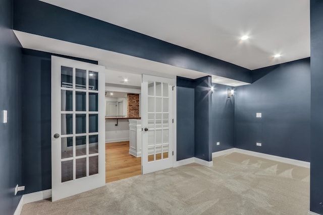 carpeted empty room with french doors and baseboards
