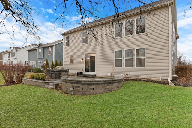back of property featuring a lawn and a patio