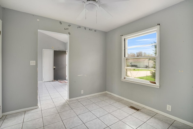 unfurnished room featuring plenty of natural light, a ceiling fan, baseboards, and light tile patterned floors