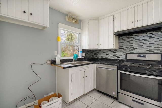 kitchen with decorative backsplash, appliances with stainless steel finishes, a sink, and white cabinets