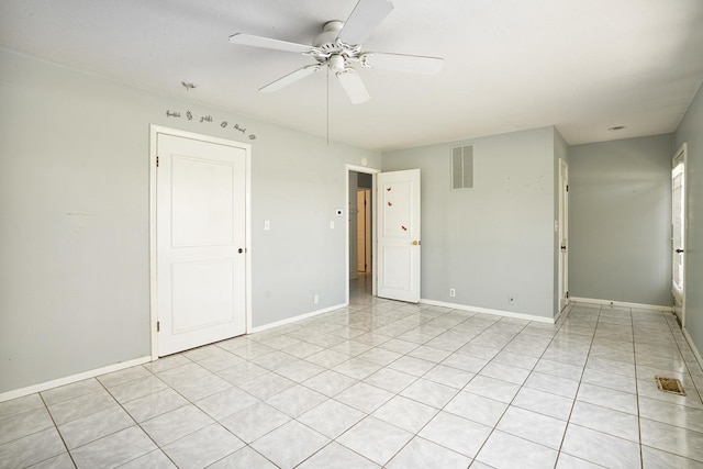 empty room featuring baseboards, a ceiling fan, visible vents, and light tile patterned flooring